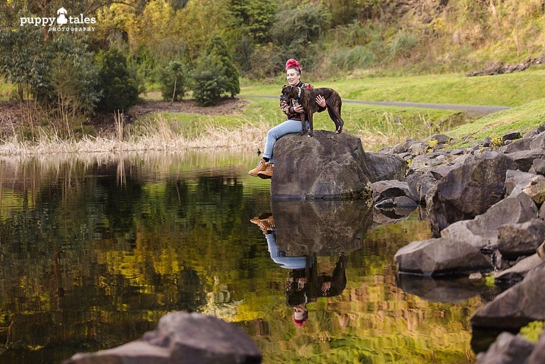 Lulu the boxer and her human photographed near a lake in Wilson Botanic Park