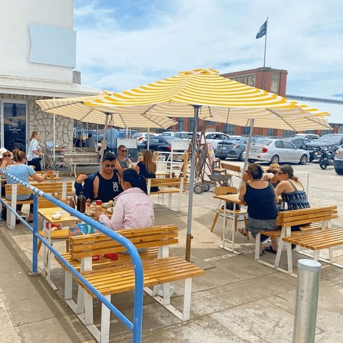 Outdoor dining area of a cafe that is dog friendly in Melbourne with many people dining outside