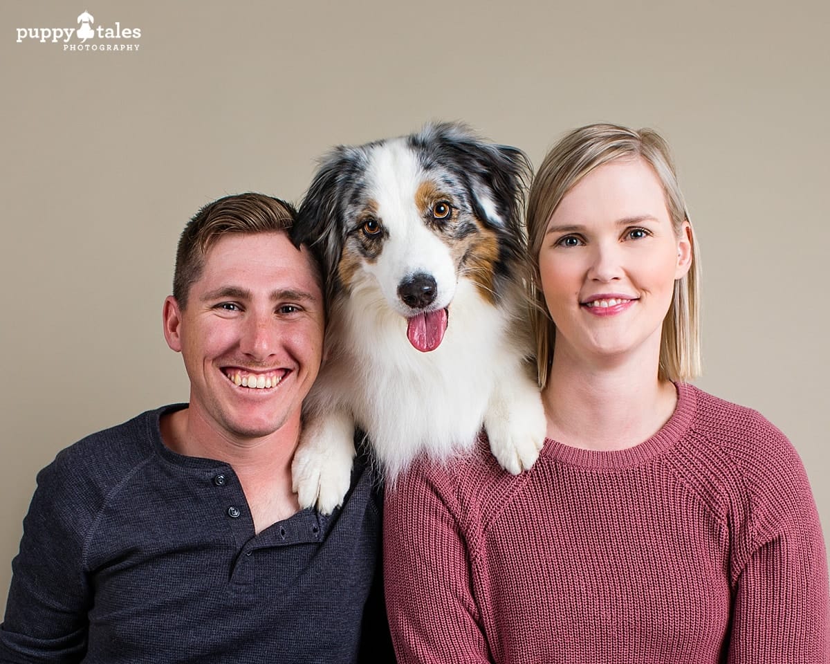 Australian Shepherd Mia is photographed with her people on a silvertone background in the Puppy Tales studio for Project Dogalogue.